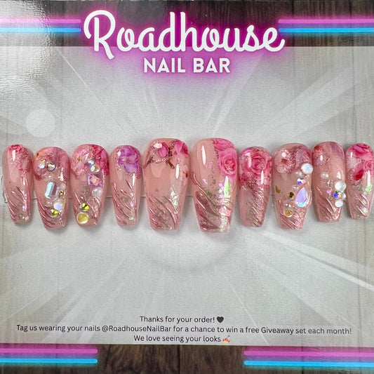 Luxury pink press-on nails featuring 3D roses, pearls and romantic textured detailing.