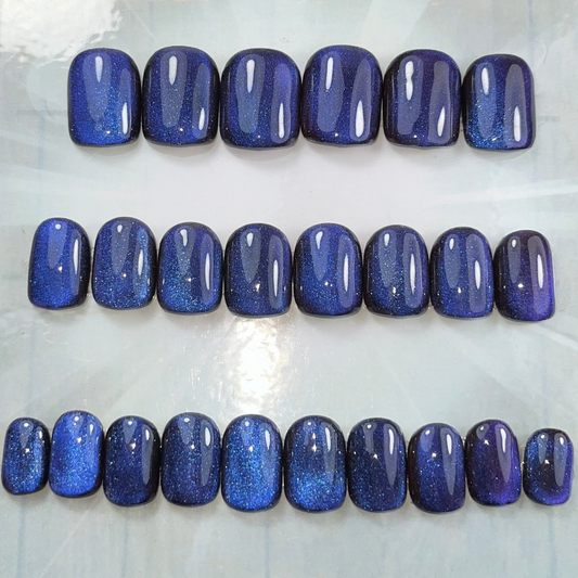 Extra short square press-on nails with shifting cat eye design in blue, purple, and pink tones. Handmade and glossy for a magical, salon-quality finish
