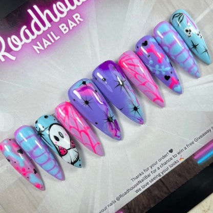Pastel goth press-on nails featuring cute ghosts, pastel spiderwebs and hand-painted pink, blue and purple nail art.