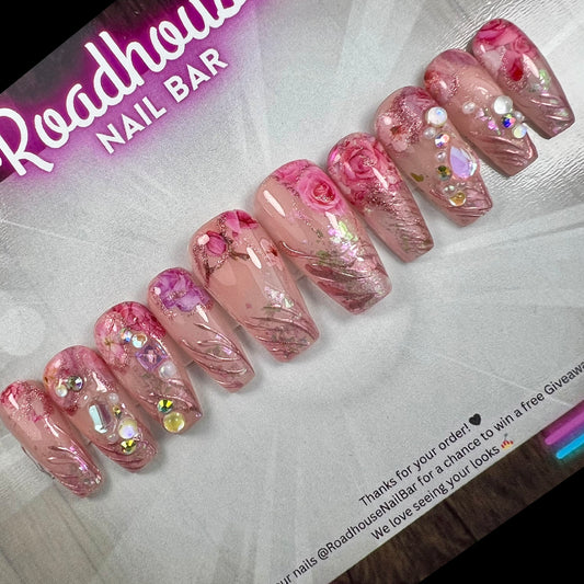Luxury pink press-on nails featuring 3D roses, pearls and romantic textured detailing.