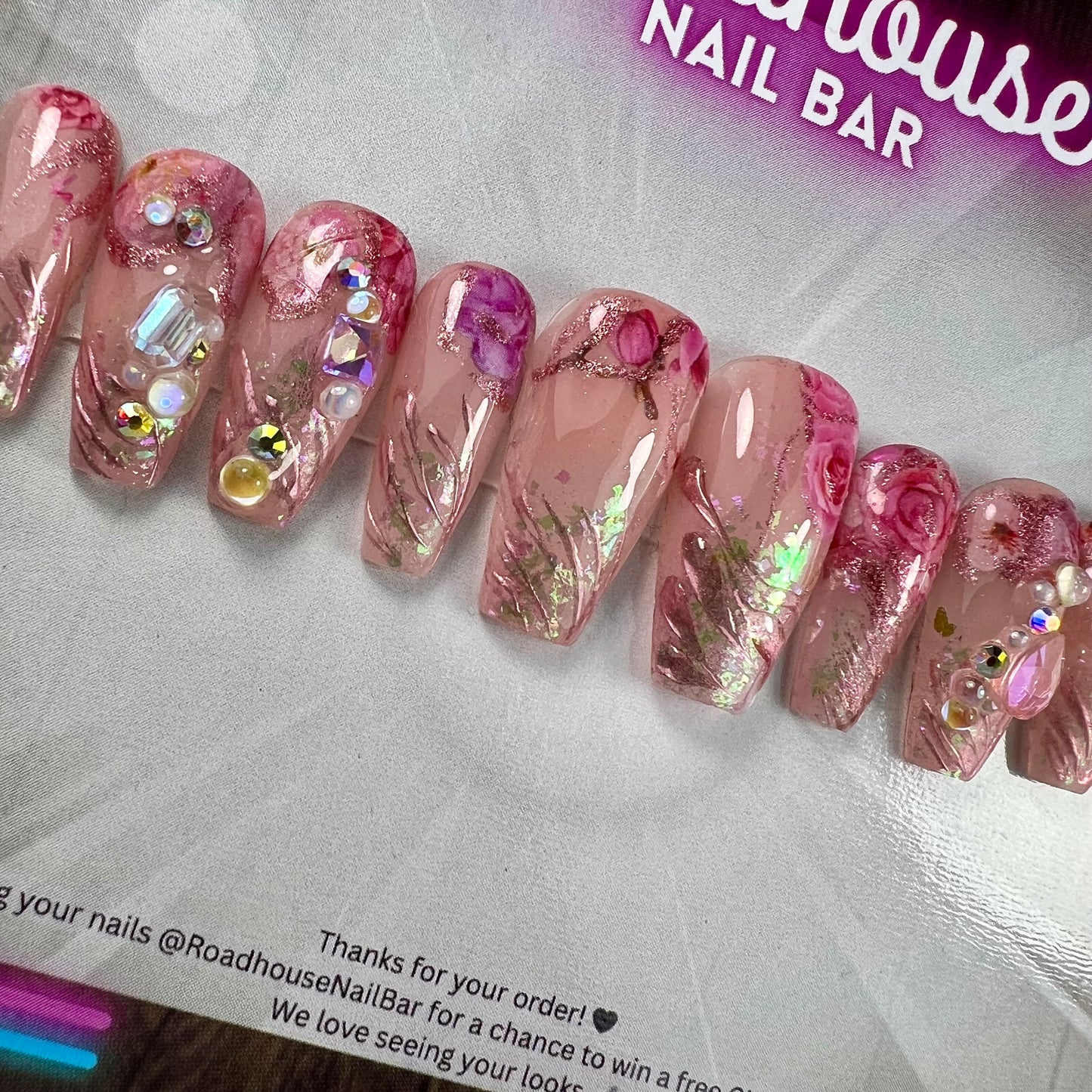 Luxury pink press-on nails featuring 3D roses, pearls and romantic textured detailing.