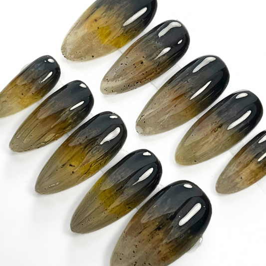 10-piece press-on nail set inspired by wolves, featuring a dark grey to golden brown ombré with claw-like texture and luxe earthy tones. Perfect for witchy, wiccan, and nature-loving styles.

