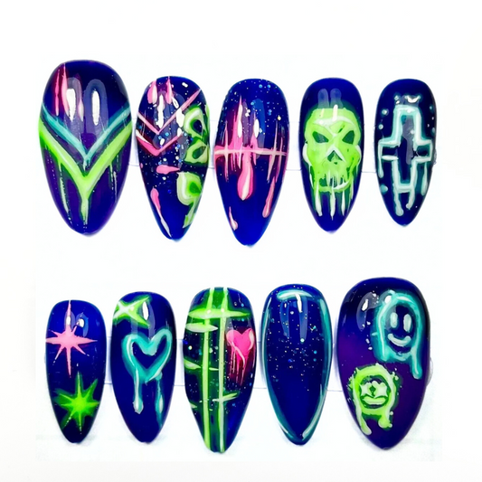 UV-reactive press-on nails featuring neon graffiti symbols and glitch art with a glossy finish. Colour-changing design inspired by cyberpunk and Tokyo rave aesthetics.