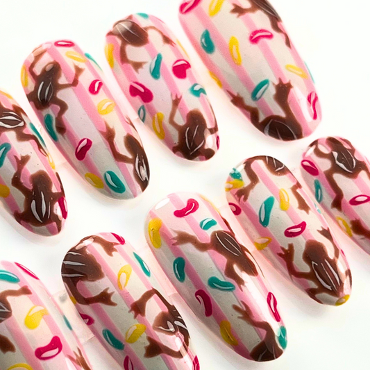 Whimsical candy-themed press-on nails inspired by chocolate frogs and jelly beans, hand-painted in a customisable 10-piece set with playful colours.