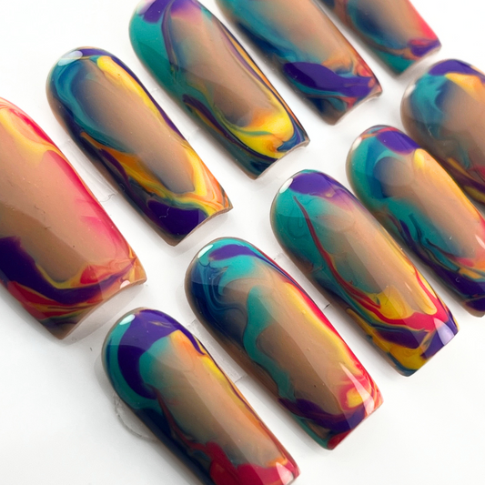 Vibrant hand-painted press-on nails with abstract summer sunset swirls in red, yellow, purple, teal, and orange on a nude base, shown in medium square.