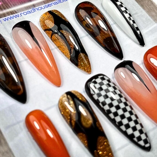 Hand-painted punk rock press-on nail set in medium square shape, featuring black, chrome, and graffiti-style details. Designed as a 10-piece custom concert-inspired set with a bold, grungy aesthetic and reusable finish.

