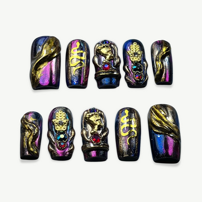 Hand-painted press-on nail set with black-purple multichrome base, featuring 3D gold Hamsa hand, snakes, and gothic baroque embellishments.

